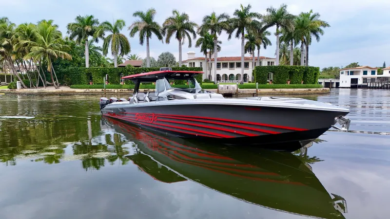 Slide: The Image of 2022 Nor-Tech 50 Sport boat on calm water, surrounded by palm trees and luxury homes. - 28
