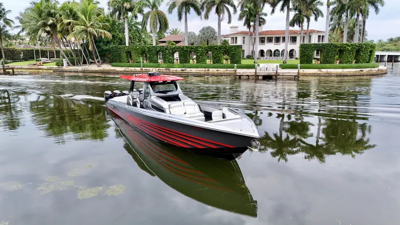 Slide: The Image of 2022 Nor-Tech 50 Sport boat cruising near a luxurious waterfront estate with palm trees. - 31