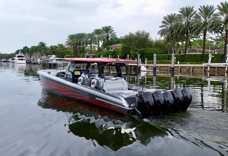 Slide: The Image of 2022 Nor-Tech 50 Sport boat with multiple engines cruising near palm-lined waterfront. - 33