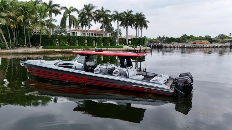 Slide: The Image of 2022 Nor-Tech 50 Sport boat with red accents docked near palm trees. - 35