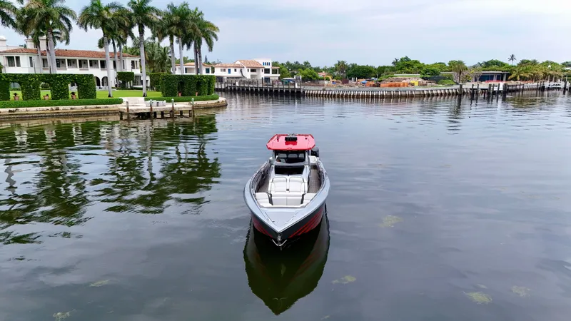 Slide: The Image of 2022 Nor-Tech 50 Sport boat on calm water near luxury waterfront homes. - 38