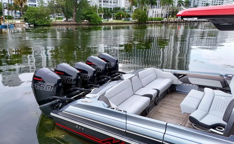 Slide: The Image of 2022 Nor-Tech 50 Sport boat with four powerful outboard engines docked by the water. - 46