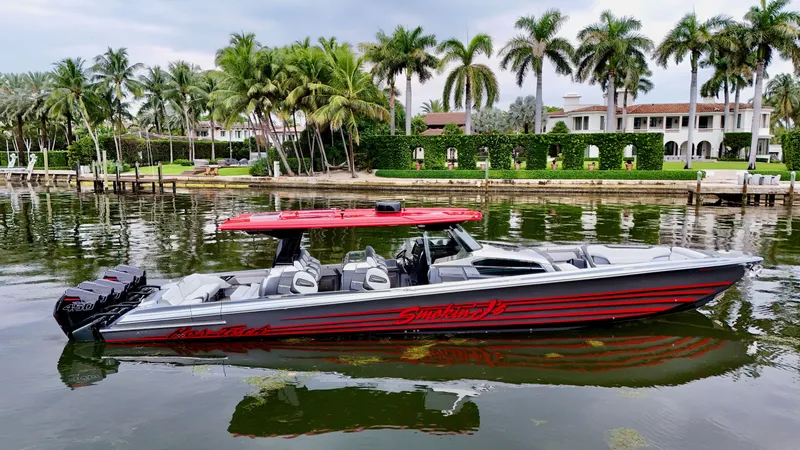 Slide: The Image of 2022 Nor-Tech 50 Sport boat on a scenic waterfront with palm trees. - 6
