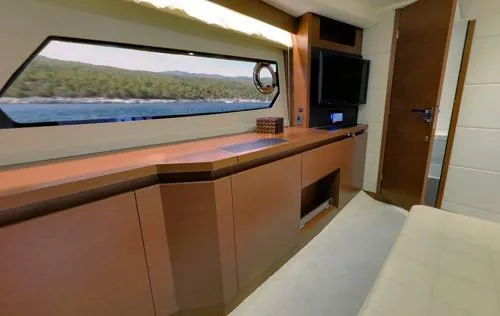 Slide: The Image of Interior of a 2016 Prestige 450 S yacht, featuring sleek cabinetry and a scenic window view. - 11