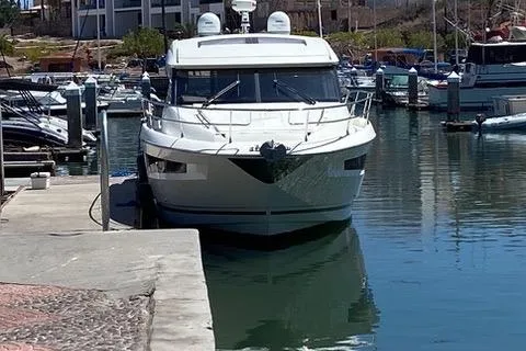 Slide: The Image of 2016 Prestige 450 S yacht docked in a marina, surrounded by calm water and other boats. - 4