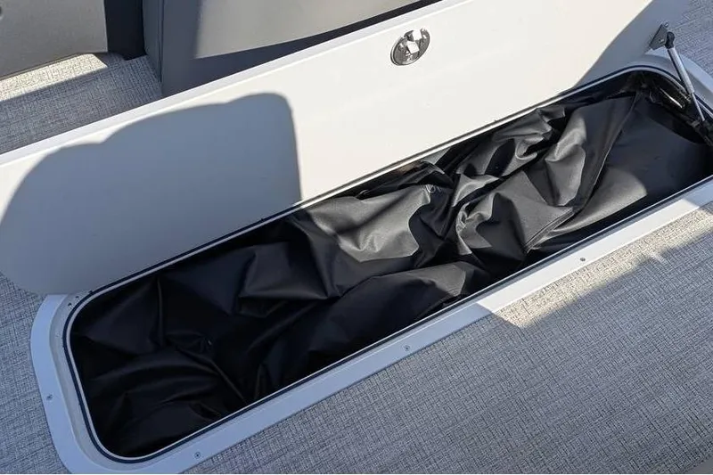 Slide: The Image of Storage compartment in 2025 Avalon 2385 LSZ CRUISE boat, featuring black interior lining. - 15