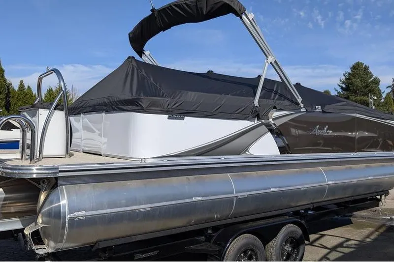 Slide: The Image of 2025 Avalon 2585 LSZ Entertainer pontoon boat with black canopy on trailer. - 3