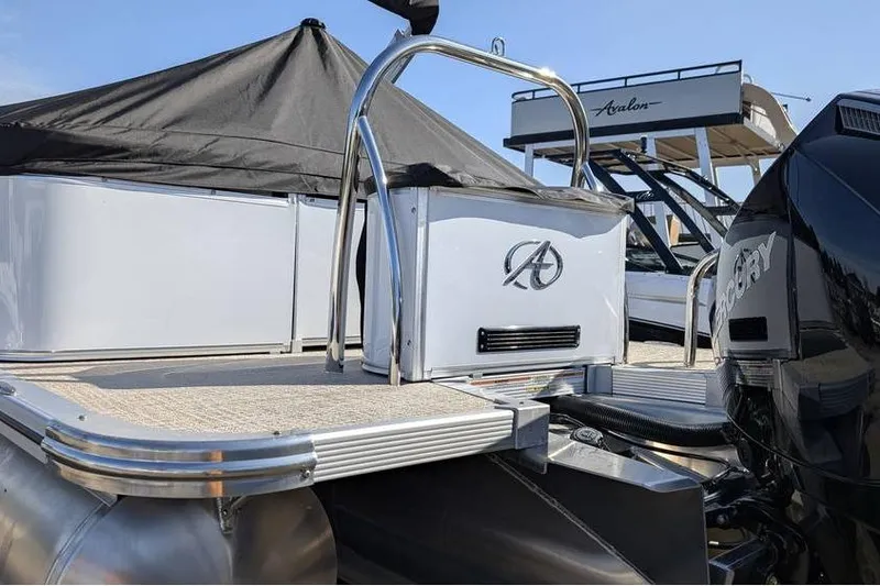Slide: The Image of 2025 Avalon 2585 LSZ Entertainer pontoon boat with Mercury engine, docked under blue sky. - 5