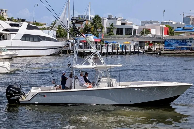 The Image of 2017 SeaVee 390Z boat cruising in a marina with passengers onboard. - 1