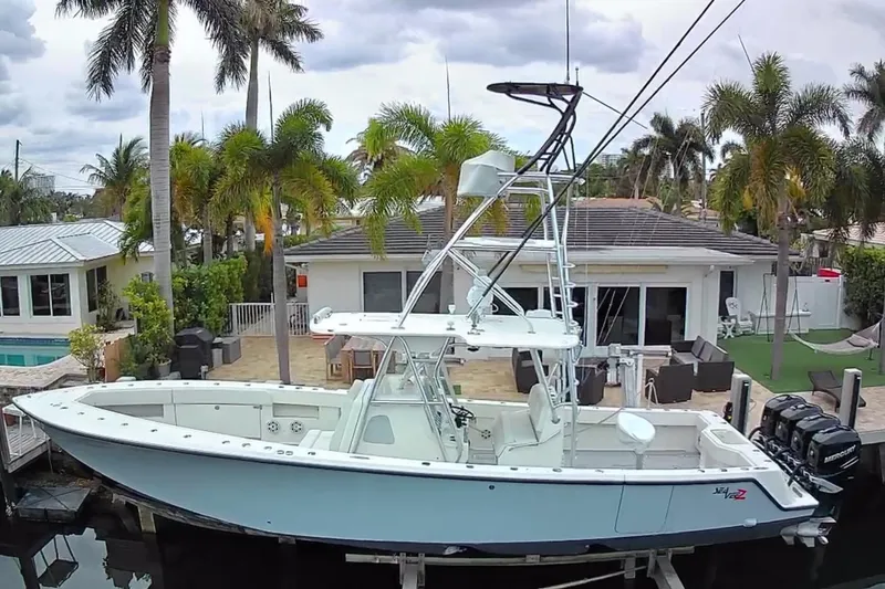 Slide: The Image of 2017 SeaVee 390Z boat docked near a tropical home with palm trees. - 3