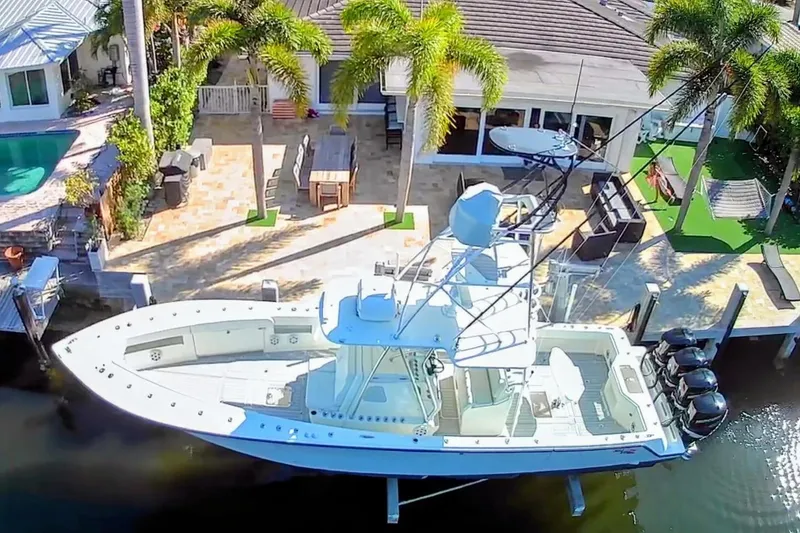 Slide: The Image of 2017 SeaVee 390Z boat docked by a luxurious waterfront home with palm trees. - 4