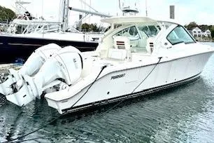 The Image of 2024 Pursuit DC 326 Dual Console boat docked in marina, featuring twin engines. - 0