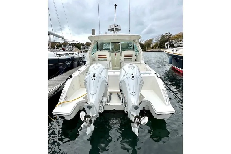 Slide: The Image of 2024 Pursuit DC 326 Dual Console boat with twin outboard engines docked in marina. - 4