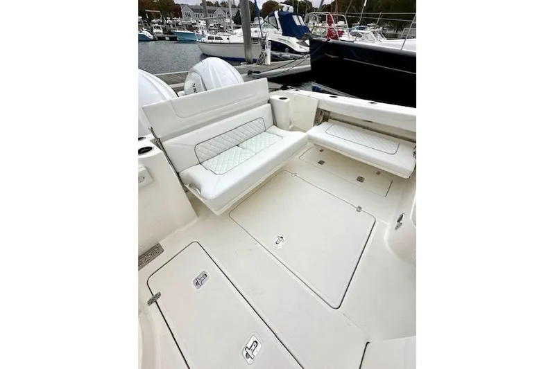 Slide: The Image of 2024 Pursuit DC 326 Dual Console boat interior with white seating and storage compartments. - 7