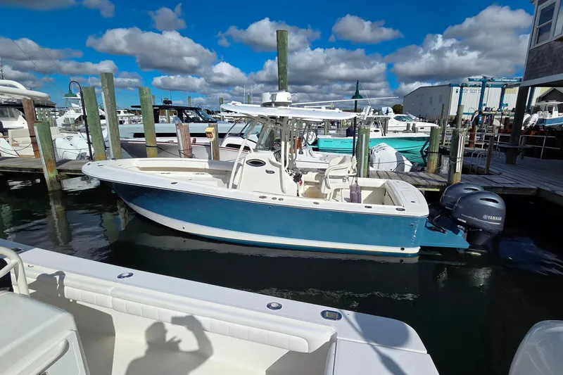 Slide: The Image of 2014 Regulator 25 boat docked with Yamaha engines, under a blue sky. - 12