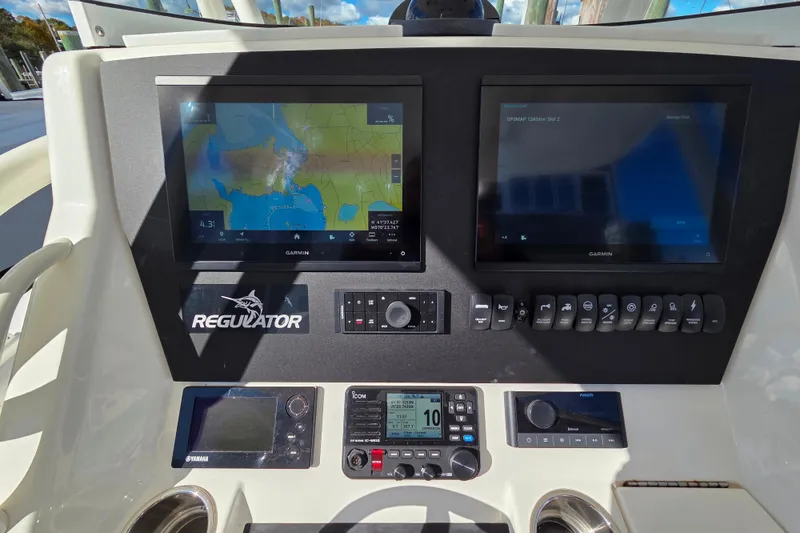 Slide: The Image of 2014 Regulator 25 boat dashboard with dual Garmin displays and control panel. - 13