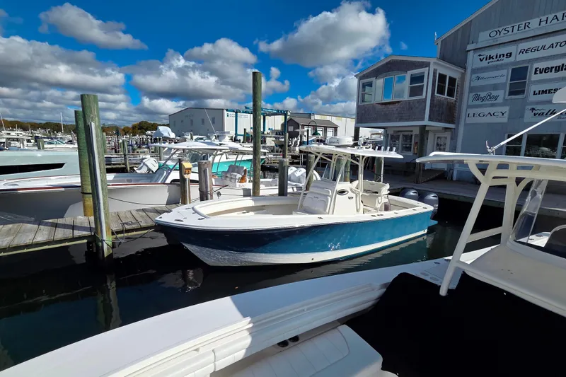 Slide: The Image of 2014 Regulator 25 boat docked at marina under blue sky. - 2
