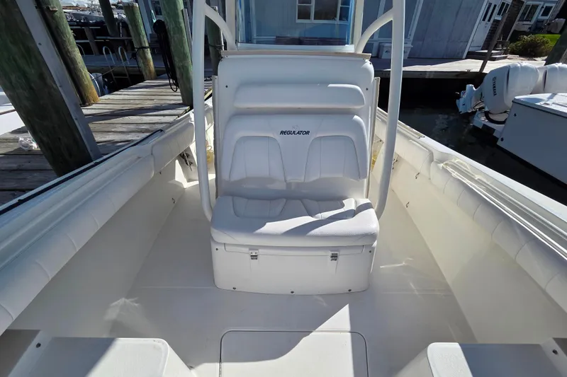 Slide: The Image of 2014 Regulator 25 boat interior with cushioned seating and console. - 7