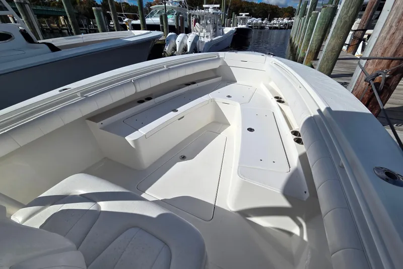 Slide: The Image of 2014 Regulator 25 boat interior with spacious seating and storage at a marina. - 9