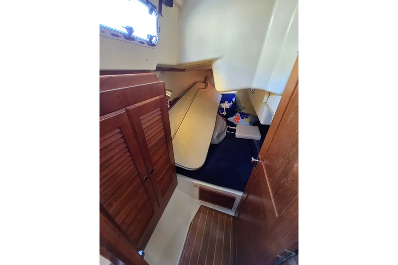 Slide: The Image of 1988 Pearson 362 Centerboard cabin interior with wooden doors and compact storage space. - 18