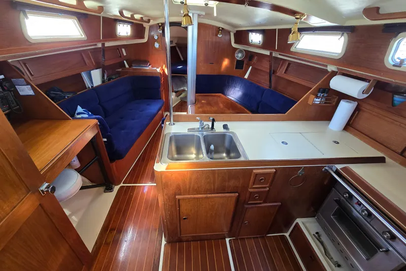 Slide: The Image of Interior of 1988 Pearson 362 Centerboard sailboat with wood finish and blue seating. - 2