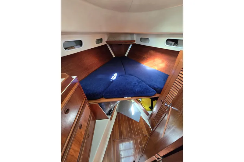 Slide: The Image of Interior cabin of 1988 Pearson 362 Centerboard sailboat with blue bedding and wooden finish. - 21