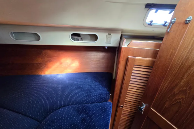 Slide: The Image of Interior cabin of 1988 Pearson 362 Centerboard sailboat with wooden finish and blue upholstery. - 23
