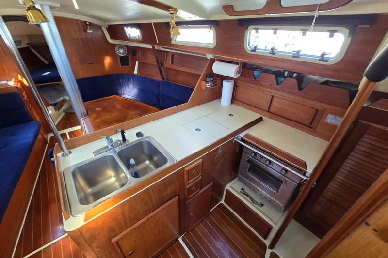Slide: The Image of Interior of 1988 Pearson 362 Centerboard sailboat with wooden cabinetry and compact kitchen. - 4