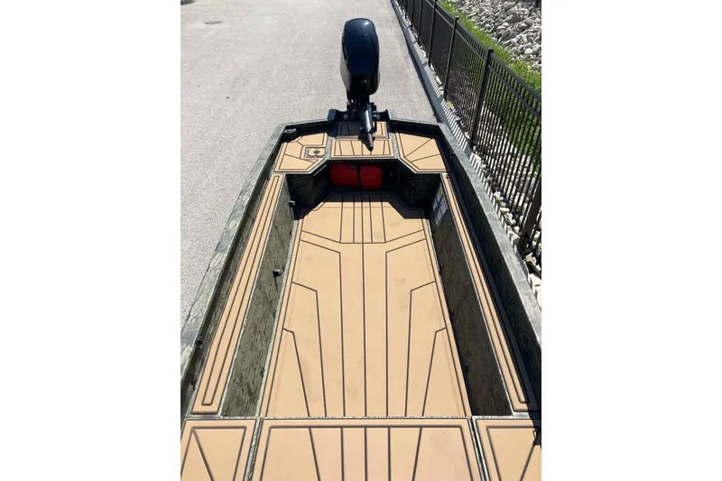 Slide: The Image of 2026 Tracker Grizzly 1650 T Prairie Wings Edition boat interior with tan deck and motor. - 9