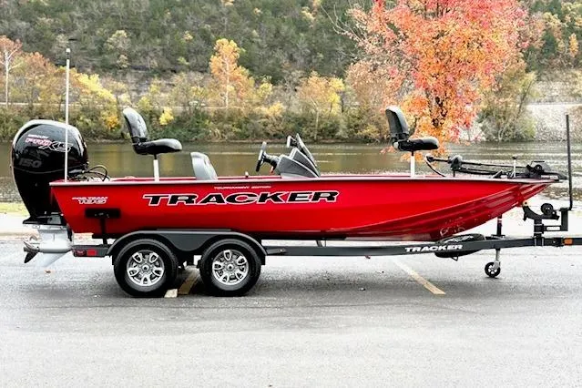 The Image of 2026 Tracker Pro Team 195 boat, red, parked by a scenic lake with autumn trees. - 0