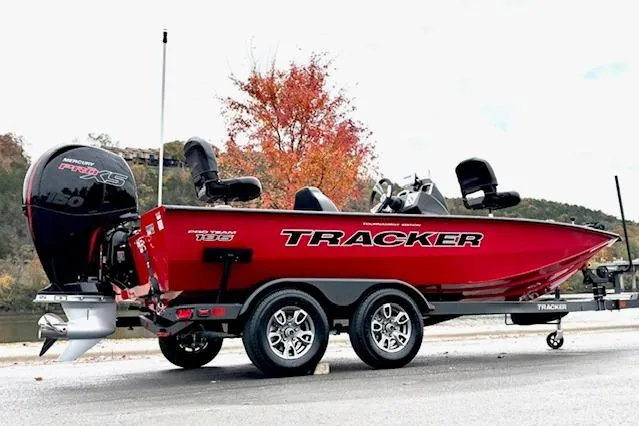 Slide: The Image of 2026 Tracker Pro Team 195 boat, red, on trailer, parked near autumn trees. - 97