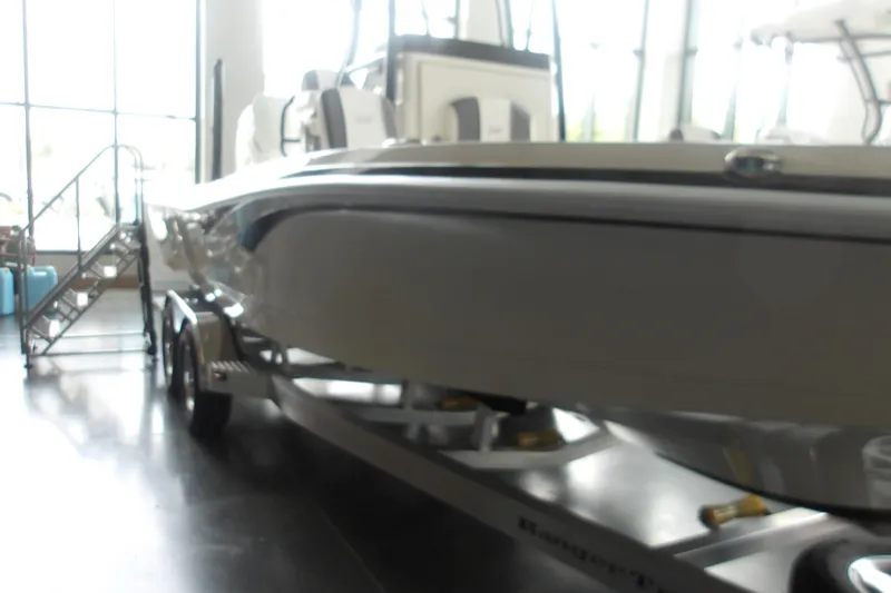 Slide: The Image of 2026 Ranger 2510 Bay boat displayed indoors on a trailer. - 23