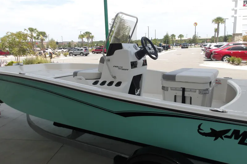 Slide: The Image of 2026 Mako Pro Skiff 15 CC boat displayed outdoors in a parking lot setting. - 66