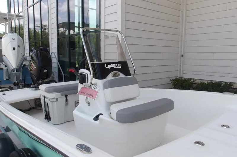 Slide: The Image of 2026 Mako Pro Skiff 15 CC boat with console and seating, displayed outdoors. - 63