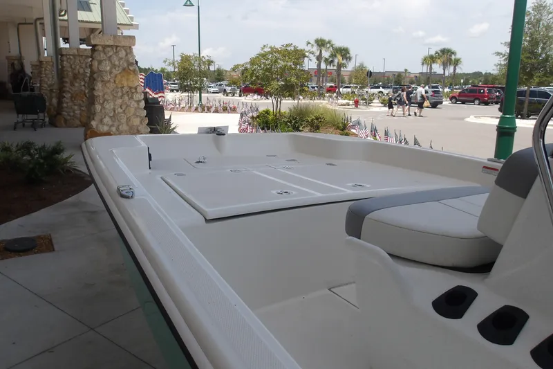 Slide: The Image of 2026 Mako Pro Skiff 15 CC boat displayed outdoors near a shopping area. - 67