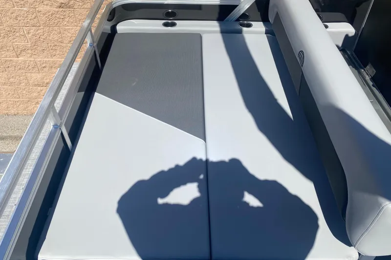 Slide: The Image of 2026 Sun Tracker Party Barge 22 RF DLX boat interior with cushioned seating and cup holders. - 10