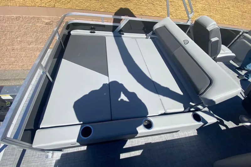 Slide: The Image of 2026 Sun Tracker Party Barge 22 RF DLX interior with gray seating and cup holders. - 11