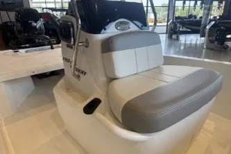 Slide: The Image of 2026 Mako Pro Skiff 13 CC boat interior with cushioned seating in showroom. - 13
