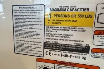Slide: The Image of Capacity and safety labels on 2026 Mako Pro Skiff 13 CC boat, detailing weight limits and compliance. - 11