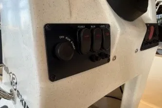 Slide: The Image of Control panel of 2026 Mako Pro Skiff 13 CC boat with switches and ignition. - 10