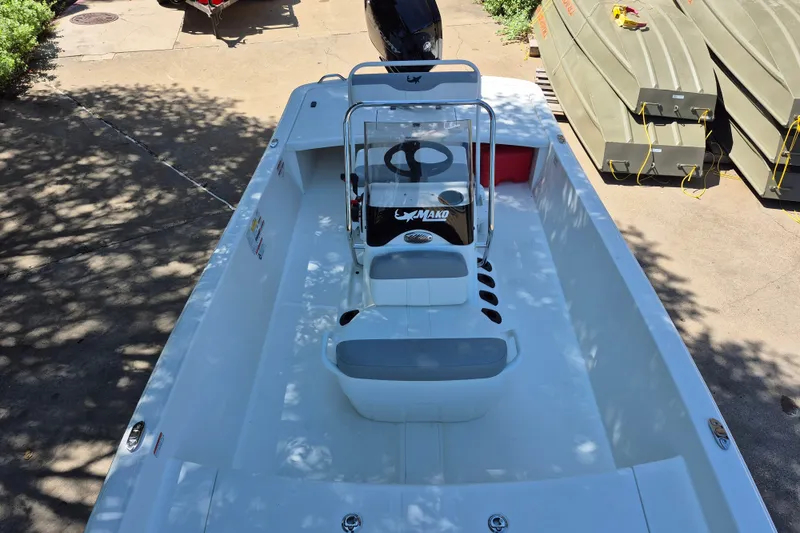 Slide: The Image of 2026 Mako Pro Skiff 17 CC boat, white interior, center console, parked on concrete. - 10