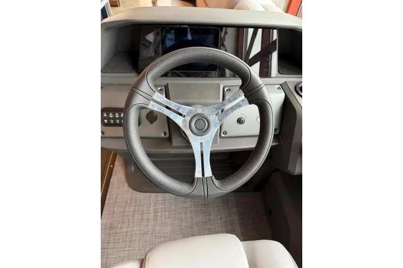 Slide: The Image of Steering wheel of 2026 Sun Tracker SportFish 22 XP3 boat, featuring modern dashboard design. - 2