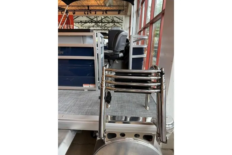 Slide: The Image of 2026 Sun Tracker SportFish 22 XP3 pontoon boat with folded ladder in showroom. - 4