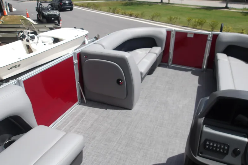 Slide: The Image of 2026 Sun Tracker Party Barge 18 DLX interior with gray seating and red paneling. - 20