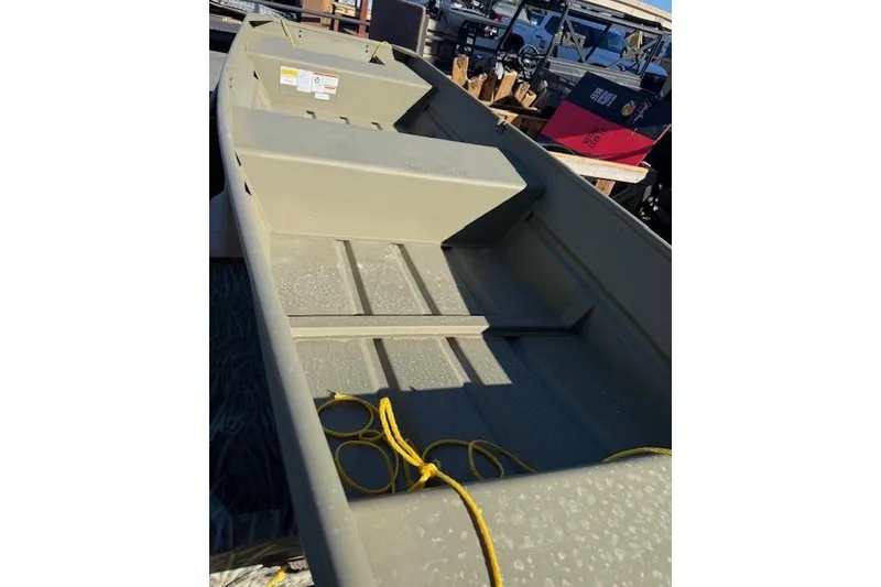 Slide: The Image of 2026 Tracker Grizzly 14 Jon boat with yellow rope, parked outdoors. - 2