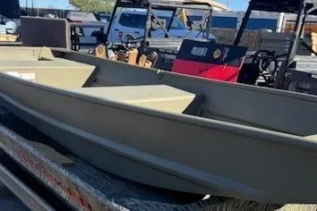 Slide: The Image of 2026 Tracker Grizzly 14 Jon boat displayed outdoors, surrounded by various vehicles. - 3