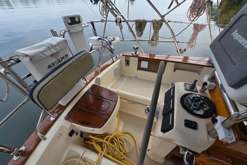 Slide: The Image of Cockpit of 2001 Island Packet 420 sailboat with polished wood table and seating. - 18