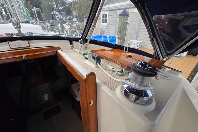 Slide: The Image of Cockpit of 2001 Island Packet 420 sailboat with winches and ropes, docked by a calm river. - 27