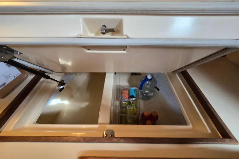 Slide: The Image of Storage compartment on a 2001 Island Packet 420 yacht, containing drinks and a water bottle. - 36