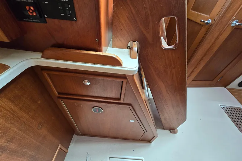 Slide: The Image of Interior of 2001 Island Packet 420 sailboat, featuring wooden cabinetry and foldable table. - 39
